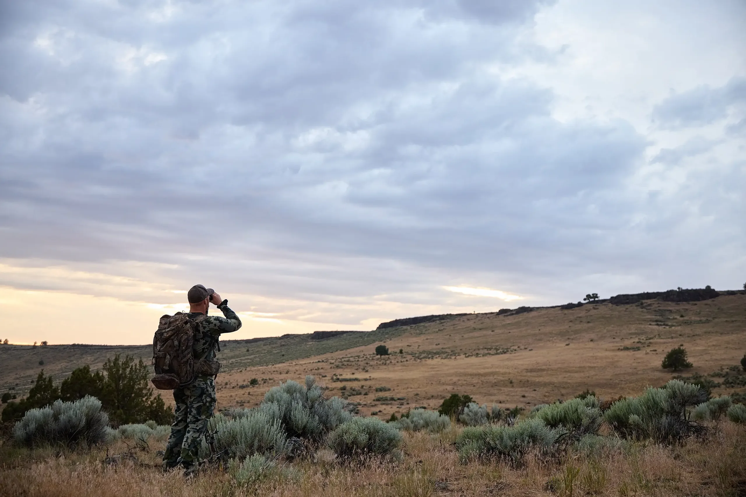 A hunter scoping the Harney County mountain range.
